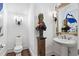 This powder bath features a pedestal sink and elegant light fixtures at 8308 Society Pl, Raleigh, NC 27615
