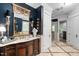 This primary bath features elegant lighting, marble counters, and dual sinks at 8308 Society Pl, Raleigh, NC 27615