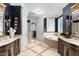 This primary bath features elegant lighting, dual sinks, and a soaking tub at 8308 Society Pl, Raleigh, NC 27615