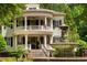 Stately two-story home featuring a double veranda, fountain, beautiful landscaping, and black shutters at 8308 Society Pl, Raleigh, NC 27615