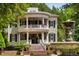 Stately two-story home featuring a double veranda, fountain, beautiful landscaping, and black shutters at 8308 Society Pl, Raleigh, NC 27615