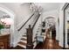 Foyer view with staircase, hardwood floors, chandelier, and decorative bust on display at 8308 Society Pl, Raleigh, NC 27615