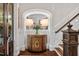 Foyer features decorative cabinet, lamps, floral arrangement and staircase at 8308 Society Pl, Raleigh, NC 27615