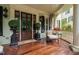 Charming front porch with seating, wood floors, and view of beautiful front door at 8308 Society Pl, Raleigh, NC 27615