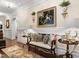 Hallway with wainscoting, hardwood floors, large painting, and decorative vases at 8308 Society Pl, Raleigh, NC 27615