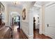 Hallway with archways, hardwood floors, wainscoting, and antique furniture at 8308 Society Pl, Raleigh, NC 27615