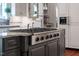 The island features a gas stove and beautiful gray cabinets at 8308 Society Pl, Raleigh, NC 27615