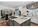 Open concept kitchen with a center island, granite counters, stainless steel appliances, and custom window treatments at 8308 Society Pl, Raleigh, NC 27615