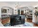 Living area featuring a dark wood bar, with hardwood floors and open archways leading to multiple sitting areas at 8308 Society Pl, Raleigh, NC 27615
