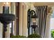 Charming front porch featuring an ornate exterior light fixture and striped privacy curtains at 8308 Society Pl, Raleigh, NC 27615