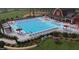 Large community pool with lounge chairs, umbrellas, and a barn-style clubhouse provides a resort-like experience at 92 Restful Pt, Fuquay Varina, NC 27526