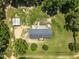Aerial view of home on a large lot, featuring a detached garage, garden, and mature trees at 921 Sweet Raspberry Lane Ln, Lillington, NC 27546