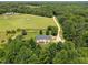 Expansive property featuring a beautiful home surrounded by lush greenery and a charming dirt road at 921 Sweet Raspberry Lane Ln, Lillington, NC 27546