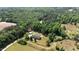 An aerial view showcases this property, nestled among a dense forest with a long dirt driveway and fenced yard at 921 Sweet Raspberry Lane Ln, Lillington, NC 27546