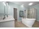 Well-lit bathroom showcasing a freestanding tub, double vanity, and glass-enclosed shower at 921 Sweet Raspberry Lane Ln, Lillington, NC 27546