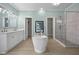 Bright bathroom featuring a soaking tub, double vanity, and a glass-enclosed shower at 921 Sweet Raspberry Lane Ln, Lillington, NC 27546