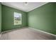 Bright bedroom featuring green walls, white trim, light wood-look floors and a window at 921 Sweet Raspberry Lane Ln, Lillington, NC 27546