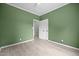 Bright bedroom featuring green walls, white trim, light wood-look floors and a closet at 921 Sweet Raspberry Lane Ln, Lillington, NC 27546