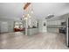Well-lit open floor plan showcasing the modern kitchen with white cabinets, stainless appliances, and views into the living room at 921 Sweet Raspberry Lane Ln, Lillington, NC 27546