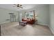 Inviting living room with new laminate flooring, natural light, a red sofa, and a ceiling fan for added comfort at 921 Sweet Raspberry Lane Ln, Lillington, NC 27546