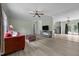 Cozy living room with modern floors, a ceiling fan, and a comfortable red couch, complemented by an open-concept kitchen at 921 Sweet Raspberry Lane Ln, Lillington, NC 27546