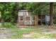 A backyard shed with a window and double doors, surrounded by grass and trees at 921 Sweet Raspberry Lane Ln, Lillington, NC 27546