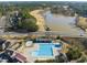 Aerial view showcases a pool, pond, golf course, and beautiful surrounding landscape at 925 Hidden Jewel Ln, Wake Forest, NC 27587