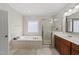 Bathroom featuring a soaking tub with tile surround, a glass shower, and a vanity at 925 Hidden Jewel Ln, Wake Forest, NC 27587