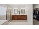 Bright bathroom featuring a double vanity, walk-in shower, and a view into the spacious walk-in closet at 925 Hidden Jewel Ln, Wake Forest, NC 27587