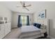 Relaxing bedroom features a plush bed, blue accents, carpet floors, and natural light from the window at 925 Hidden Jewel Ln, Wake Forest, NC 27587