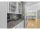 Granite-topped butler's pantry with glass-front cabinets and a view to the spacious kitchen at 925 Hidden Jewel Ln, Wake Forest, NC 27587