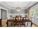 Formal dining area with coffered ceilings, chandelier, and views of the green, tree-lined backyard at 925 Hidden Jewel Ln, Wake Forest, NC 27587