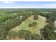A beautiful aerial view of a golf course surrounded by lush green trees and manicured fairways at 925 Hidden Jewel Ln, Wake Forest, NC 27587