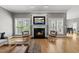 Inviting living room featuring a fireplace, hardwood floors, and natural light from two windows at 925 Hidden Jewel Ln, Wake Forest, NC 27587