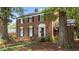 Charming brick home with manicured lawn, trimmed shrubs, and tree-lined front yard, with a black front door at 925 S Chestnut St, Henderson, NC 27536