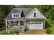 Charming home featuring stone accents, a covered front porch, and an attached two-car garage at 96 Linda Lou Ln, Angier, NC 27501