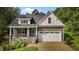 Charming home featuring stone accents, a covered front porch, and an attached two-car garage at 96 Linda Lou Ln, Angier, NC 27501