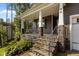 Inviting front porch with stone pillars, a porch swing, and stone stairs leading to the entrance at 96 Linda Lou Ln, Angier, NC 27501