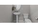 Modern powder room features a pedestal sink and a toilet with gray colored walls at 96 Linda Lou Ln, Angier, NC 27501
