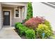 Close-up of a home's entrance, showcasing well-manicured landscaping and a secure SimpliSafe sign at 1008 Sounding Ln, Durham, NC 27703