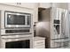 Close-up of stainless steel kitchen appliances including a microwave, oven, and refrigerator at 1008 Sounding Ln, Durham, NC 27703