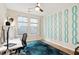 Bright home office with hardwood floors, stylish blue rug, ceiling fan, and a large window at 1008 Sounding Ln, Durham, NC 27703