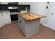 Kitchen island with white cabinets and a unique wooden countertop provides extra space and charm at 1023 Kelton Cottage Way, Morrisville, NC 27560