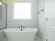 Relaxing bathroom features a soaking tub, elegant fixtures, and beautiful tiling at 1036 Smoke Willow Way, Rolesville, NC 27571