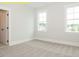 Bright bedroom featuring neutral carpet, two windows allowing natural light, and white trim for a clean aesthetic at 1036 Smoke Willow Way, Rolesville, NC 27571