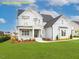 Beautifully landscaped front yard showcasing a well-maintained lawn and vibrant flowerbeds around a charming two story home at 1036 Smoke Willow Way, Rolesville, NC 27571