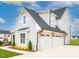 Side view of a home with a two-car garage and charming architectural details, complemented by landscaping at 1036 Smoke Willow Way, Rolesville, NC 27571