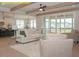 Open living room with kitchen view, wood beams, fireplace, and screened-in patio access at 1036 Smoke Willow Way, Rolesville, NC 27571