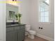 Well-lit powder room featuring a gray vanity, granite countertop, framed mirror and classic fixtures at 1036 Smoke Willow Way, Rolesville, NC 27571