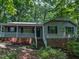 Traditional home with a covered porch, brick foundation and wooded surrounding at 1104 Theresa Ct, Raleigh, NC 27615